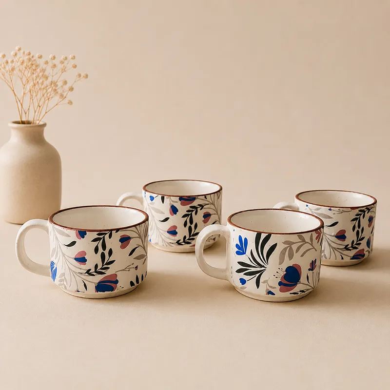 Four blue and white floral ceramic tea cups arranged together