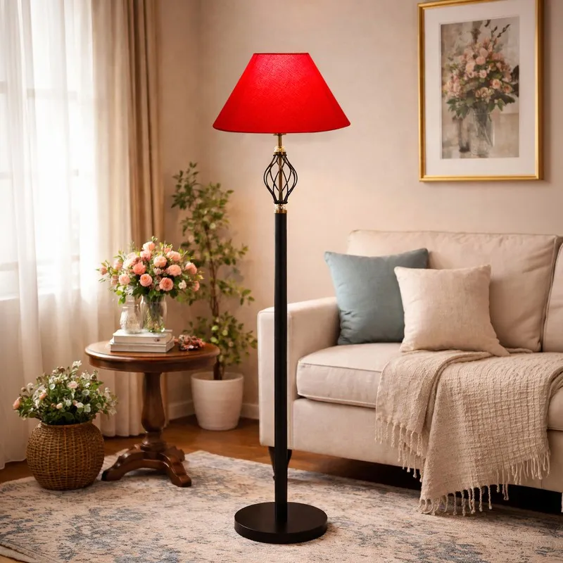 Red shade floor lamp styled near a sofa with floral decor