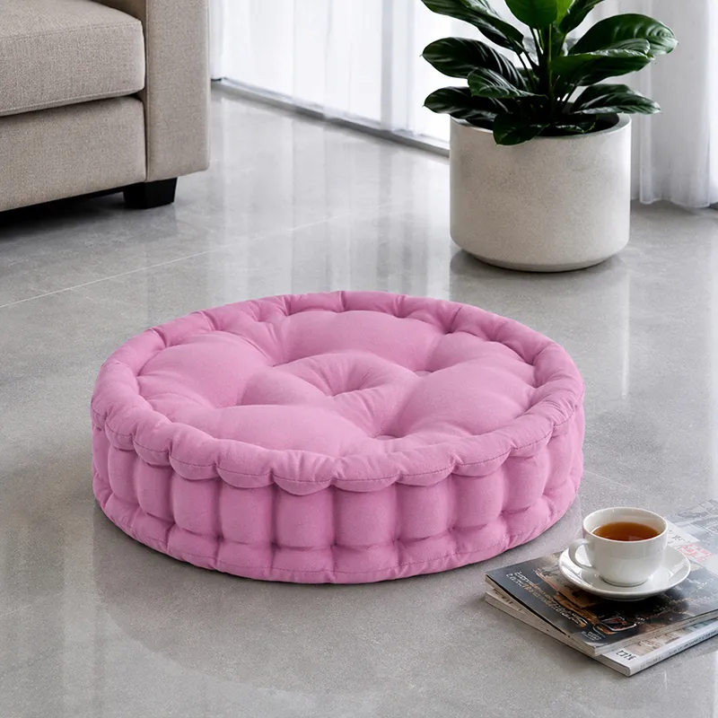 Lilac-purple round floor cushion styled on a living-room floor beside a plant.