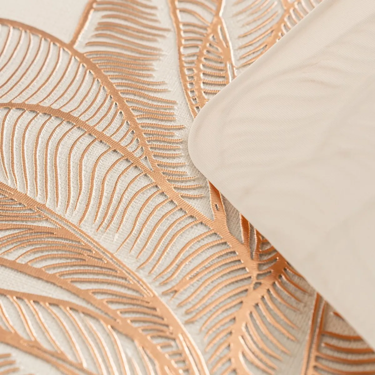 Close-up of the raised botanical pattern on the gold placemat surface