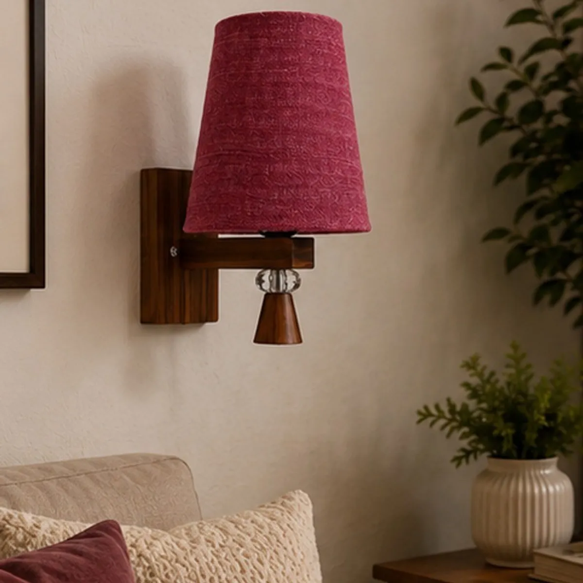Front view of a pink jute shade wall lamp with a brown wooden base