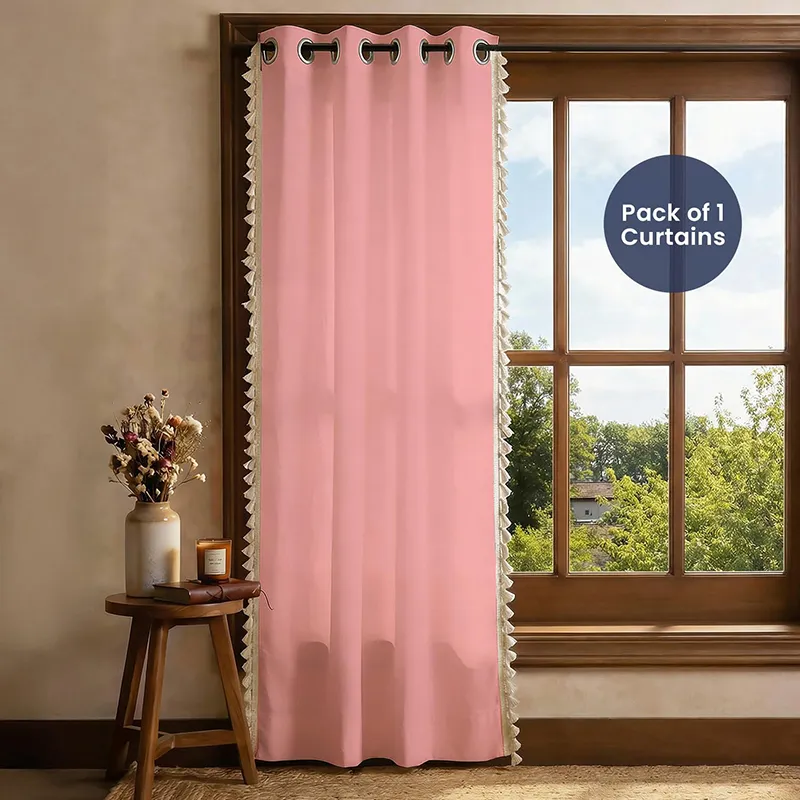 Full-length pink tasselled curtain hanging beside a window