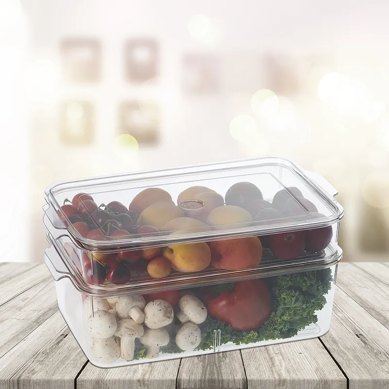 Stacked transparent organisers filled with fruit and vegetables on a wooden table.