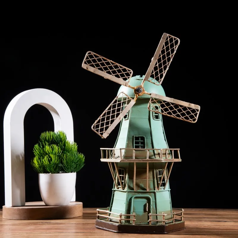 Blue windmill tabletop showpiece with cream blades against a dark background