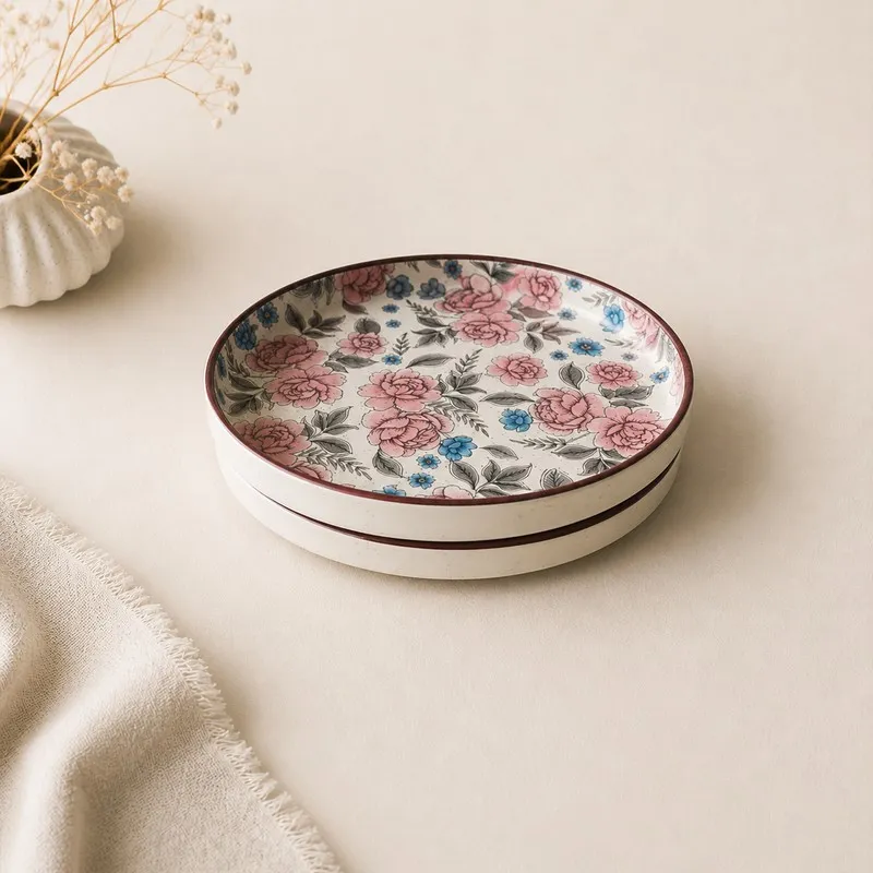 Stacked round ceramic dinner plates with pink and blue detailing