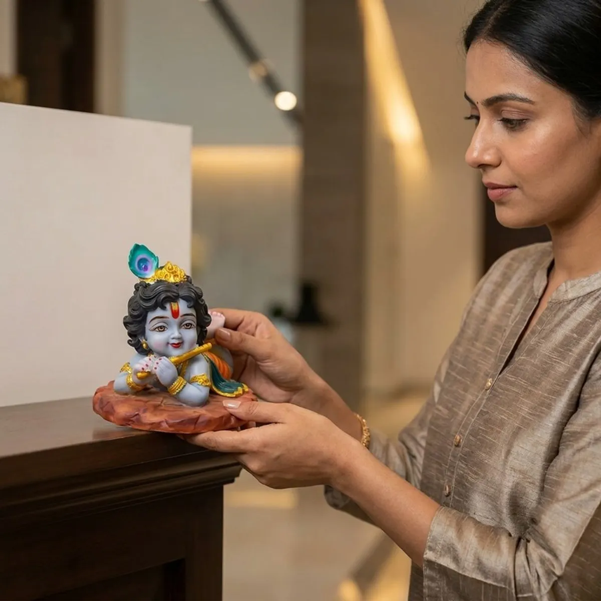 Person placing the Gopal idol on a console in a home