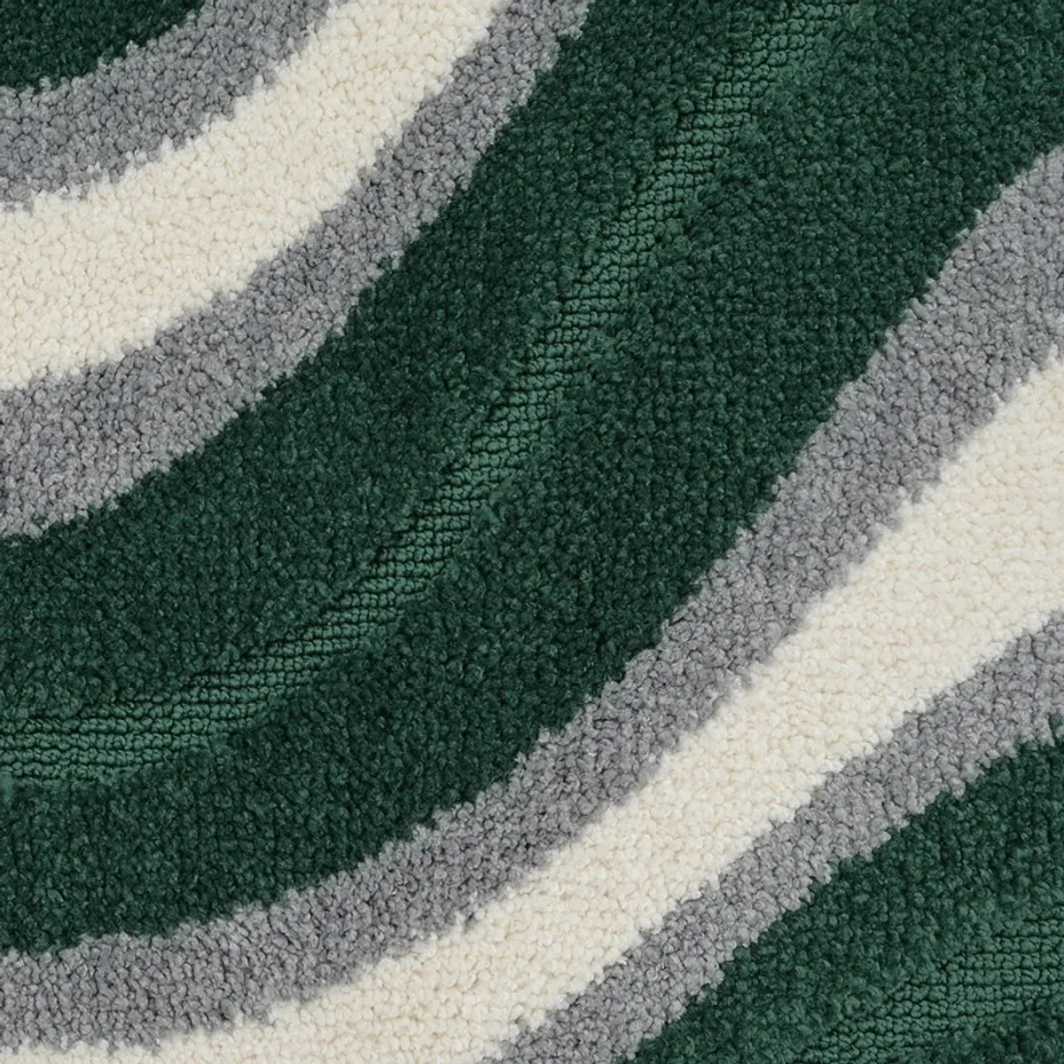 Close-up showing the plush textured surface and curved wave bands of the bath mat
