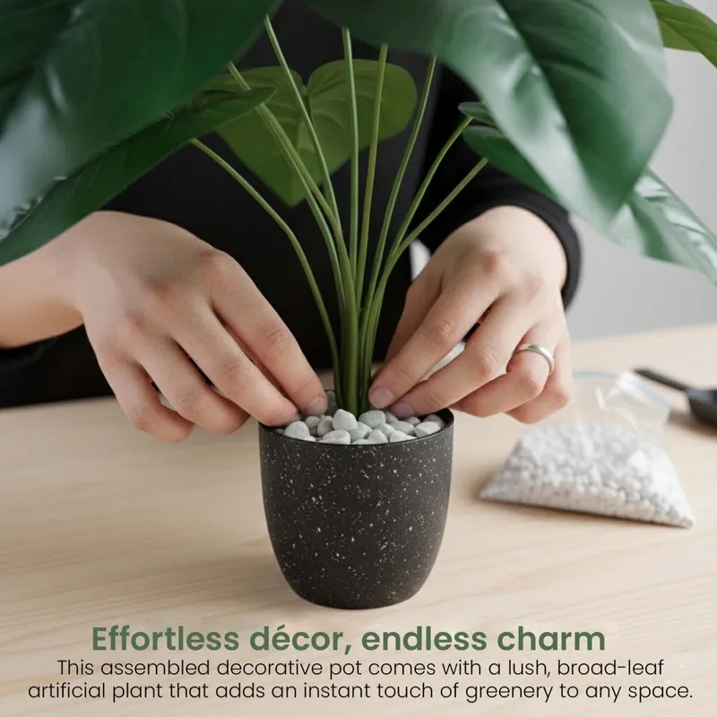 Hands arranging green stems and white pebbles in a black plant pot.
