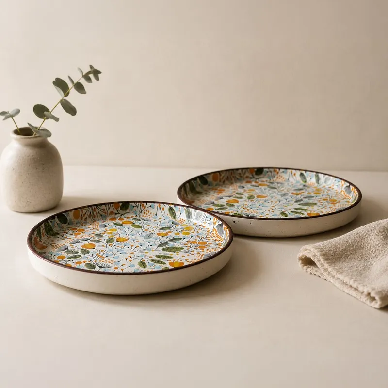 Side view of two glossy round quarter plates with a garden-inspired botanical print.