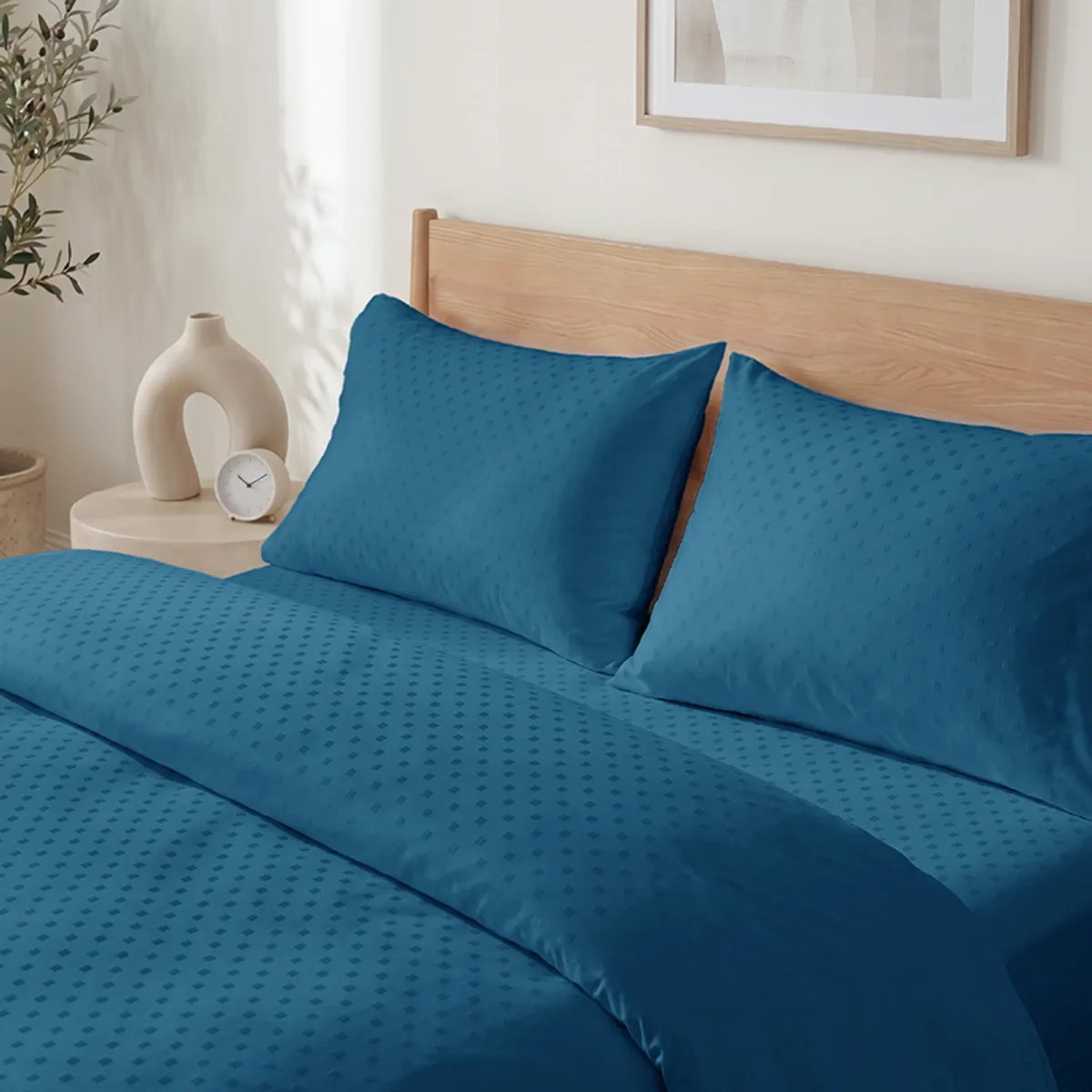 Close-up bedroom view of blue self-design duvet cover and matching pillows
