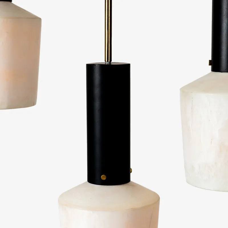 Close-up of pendant light with black cylindrical top and off-white shade