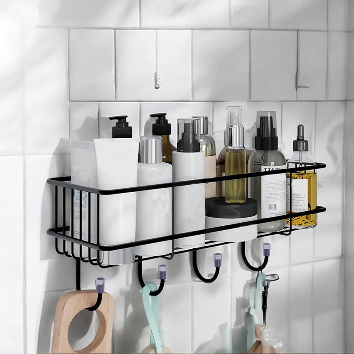 Black metal adhesive shelf with hooks mounted on a white tiled wall