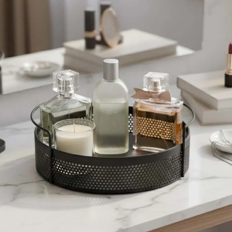 Round black metal basket with handles holding perfume bottles and a candle
