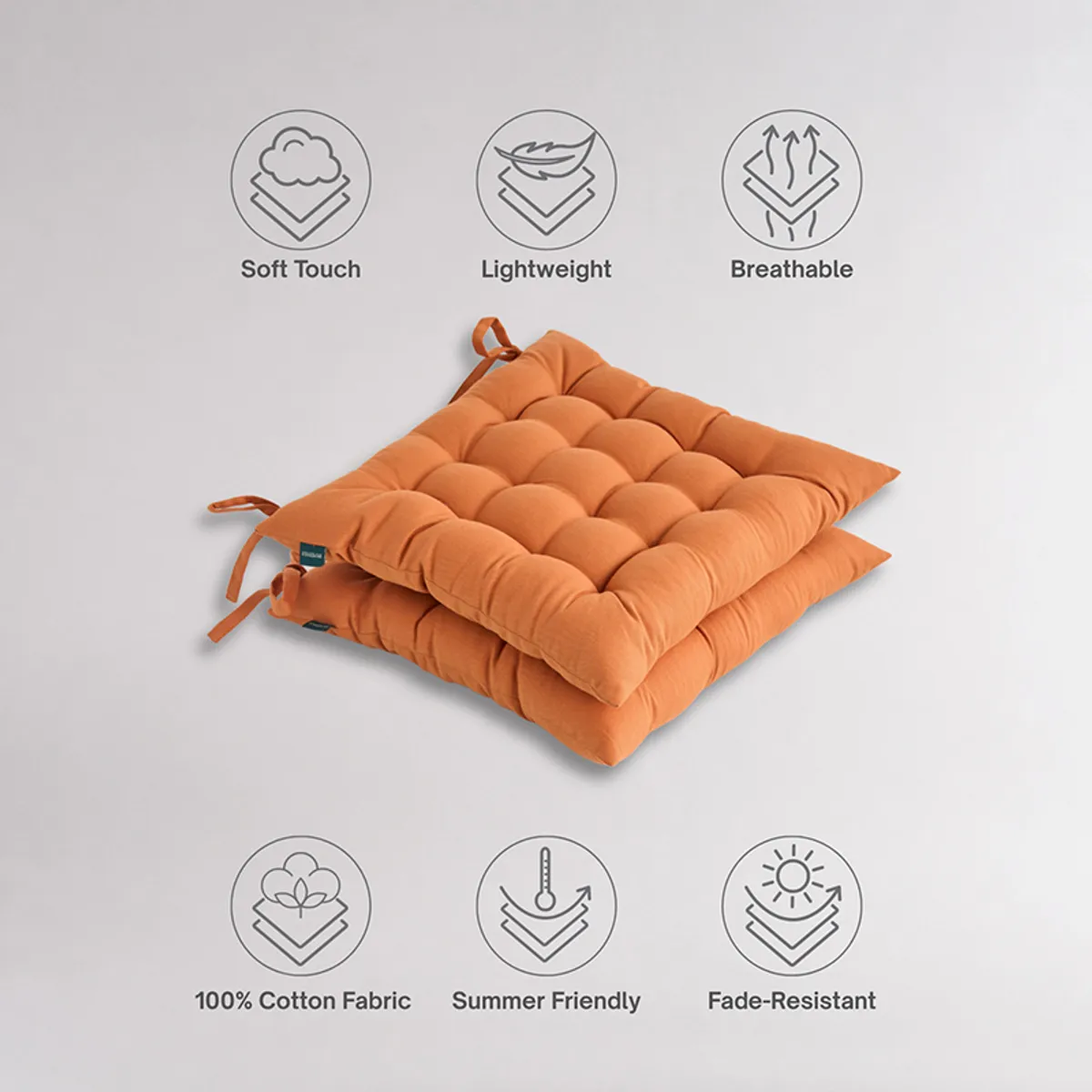 Two brown tufted chair pads stacked against a plain background
