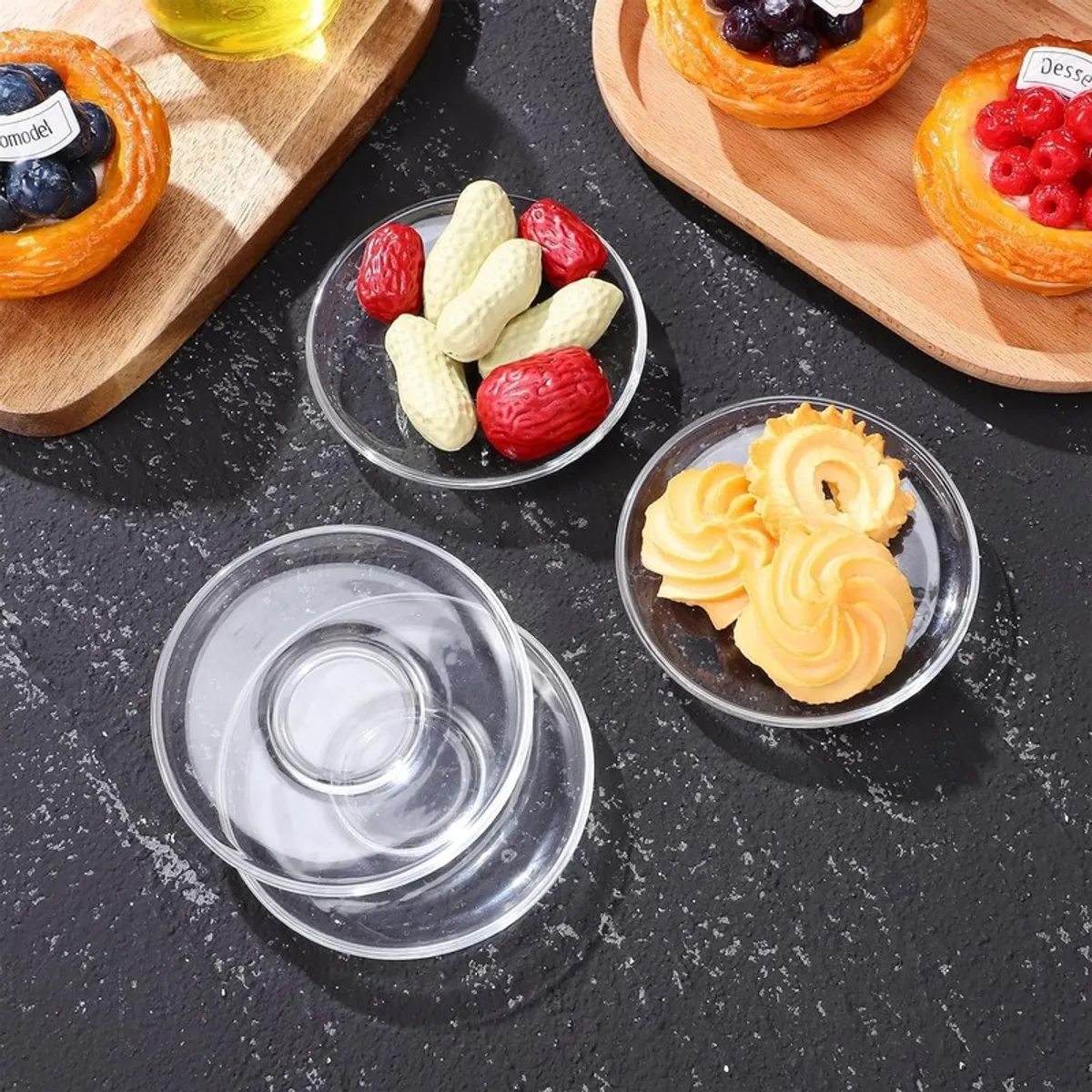 Clear glass saucers styled with biscuits and assorted snacks