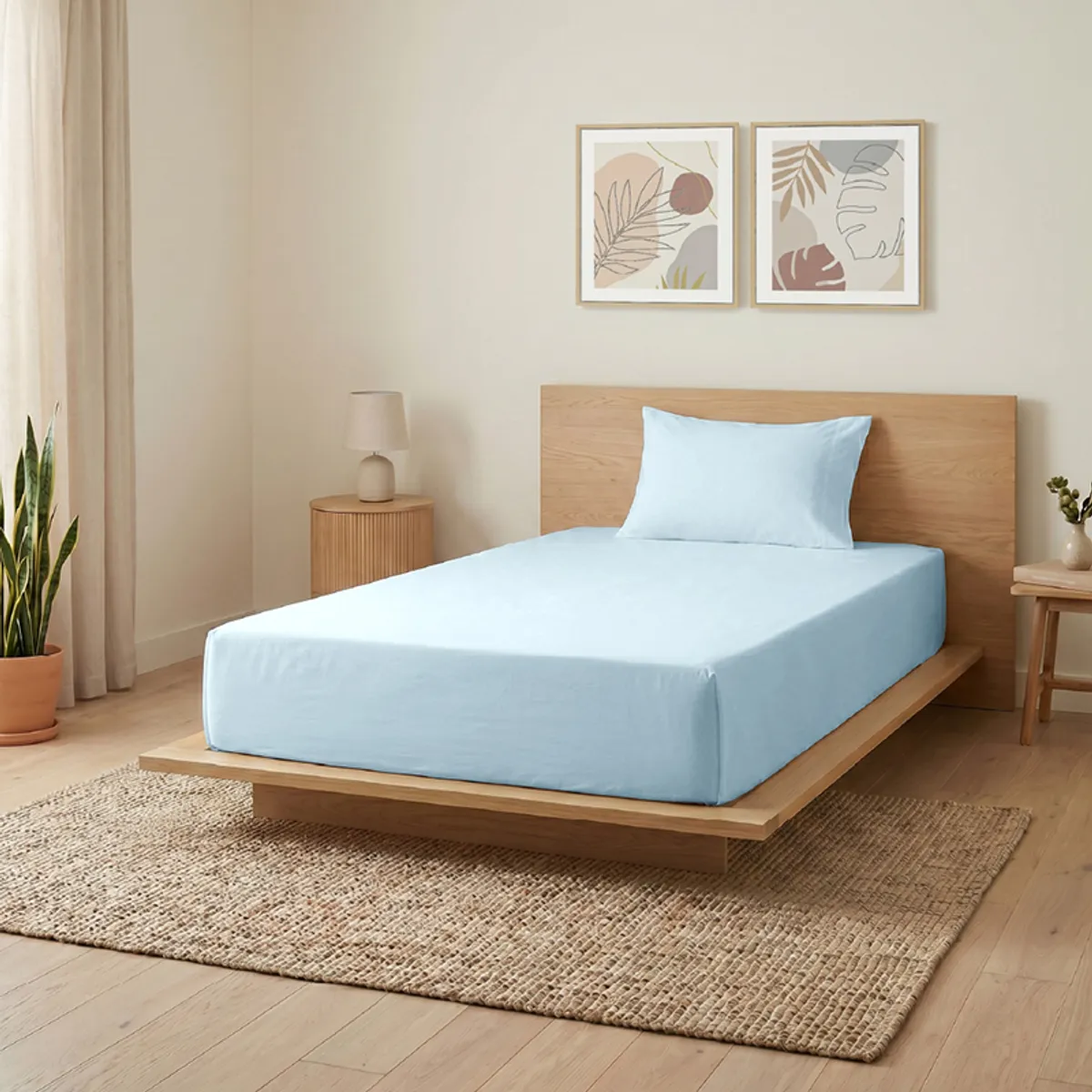 Pale blue flat bedsheet styled on a single bed in a calm modern bedroom