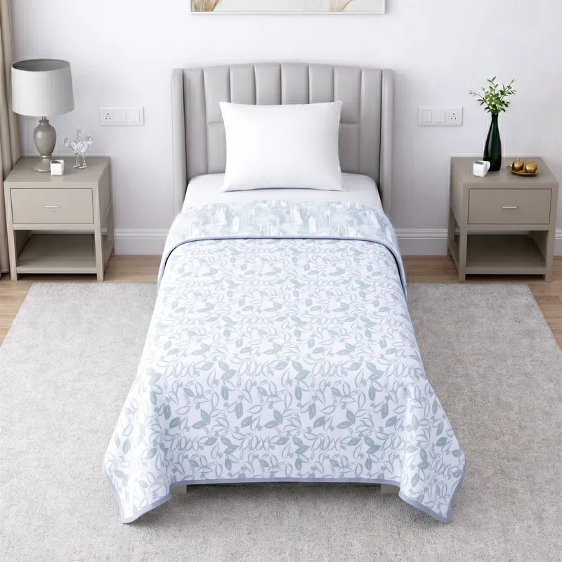 Reversed side of the white and pale green printed dohar on a single bed.