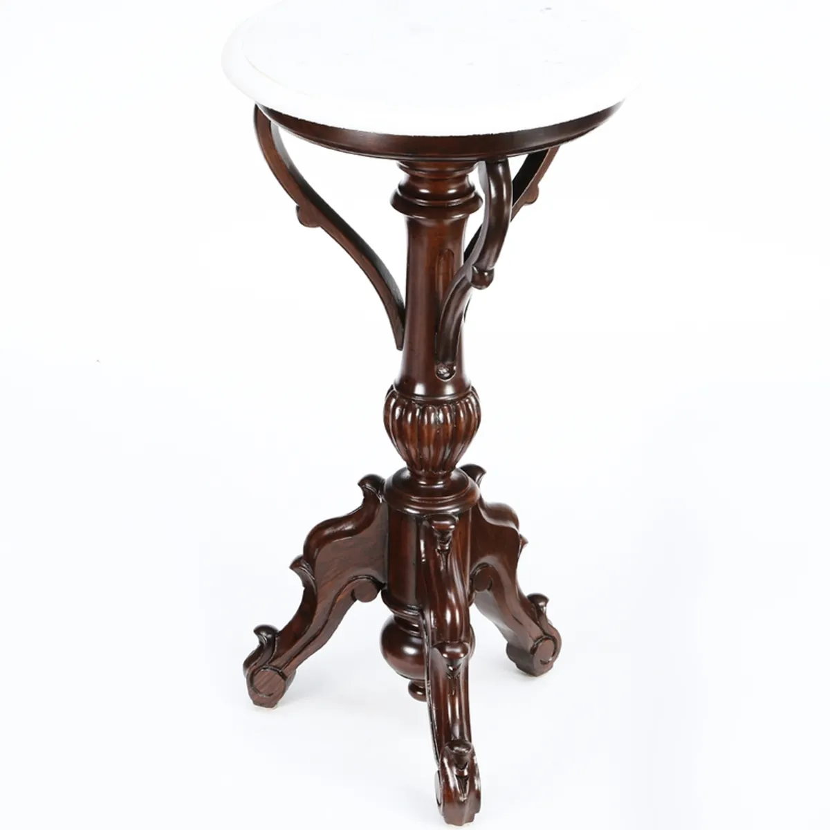 Studio view of the brown carved pedestal side table with round white top