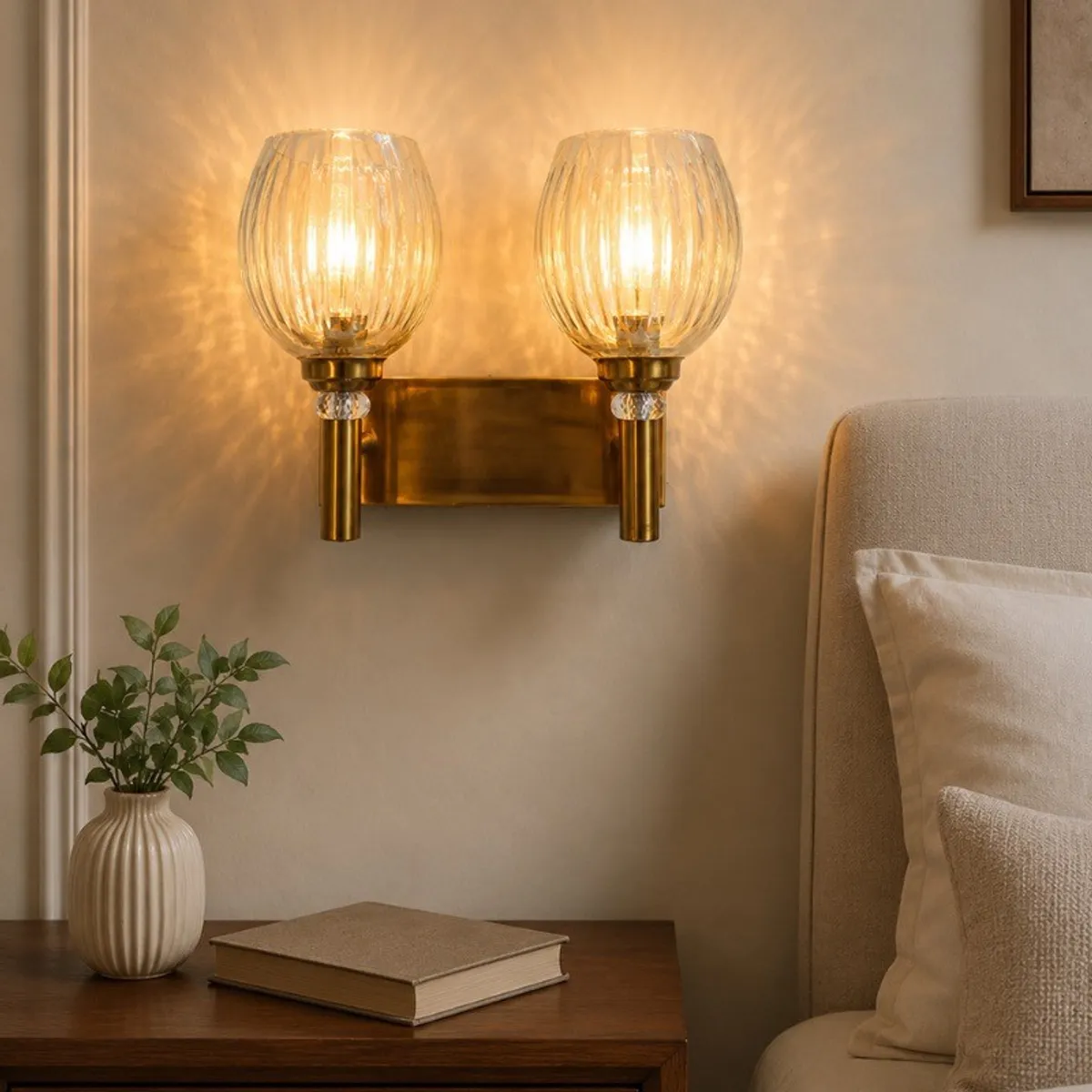 Lit gold twin wall lamp casting a warm glow through ribbed glass globes
