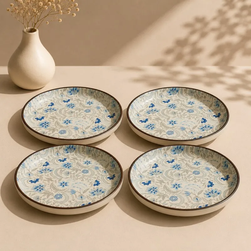 Set of four round ceramic dinner plates arranged on a tabletop