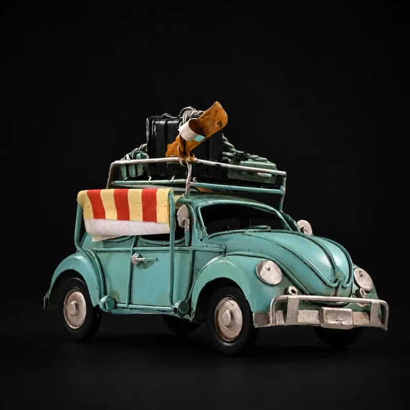 Front angled view of blue vintage beetle car showpiece with rooftop luggage