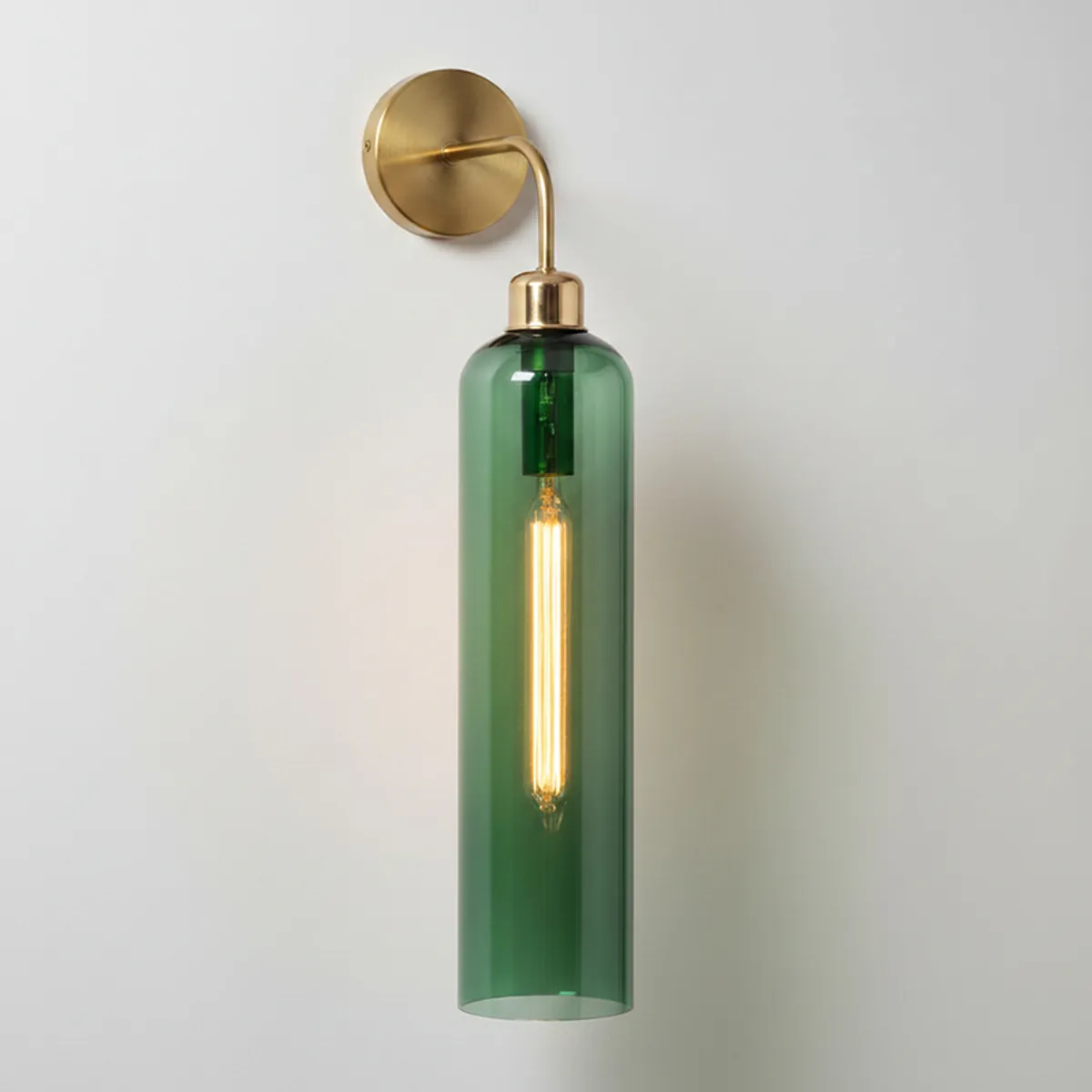 Front view of a green cylindrical glass wall lamp with gold-toned mount