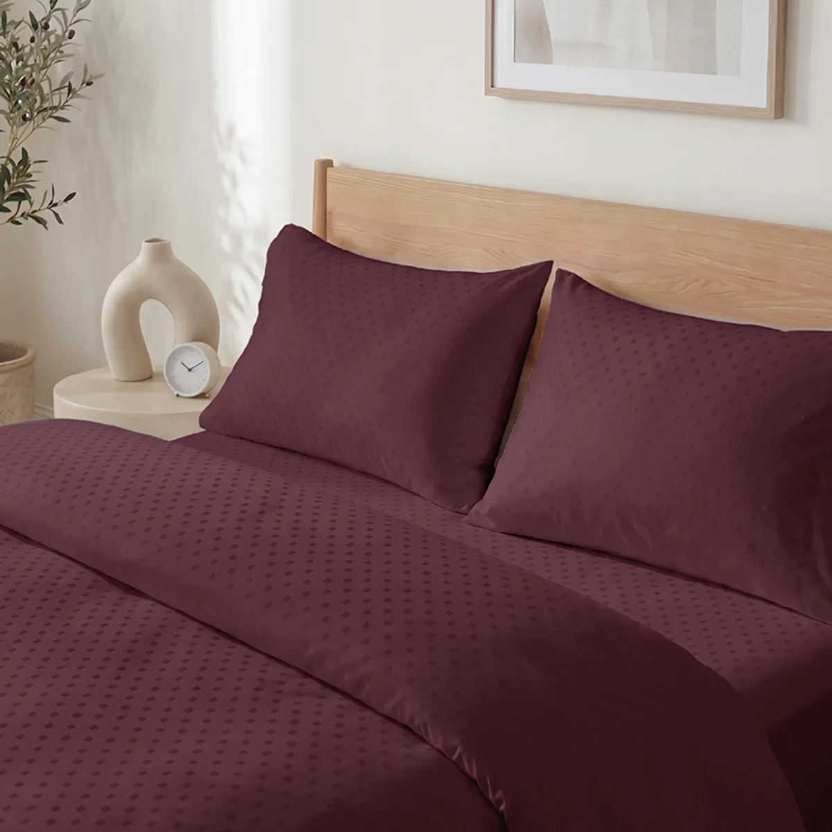 Close-up view of the maroon duvet cover's subtle geometric self-design
