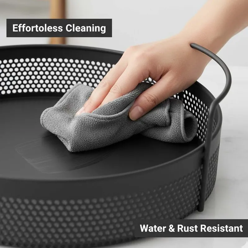 Close-up of a black round metal basket with perforated sides and handles