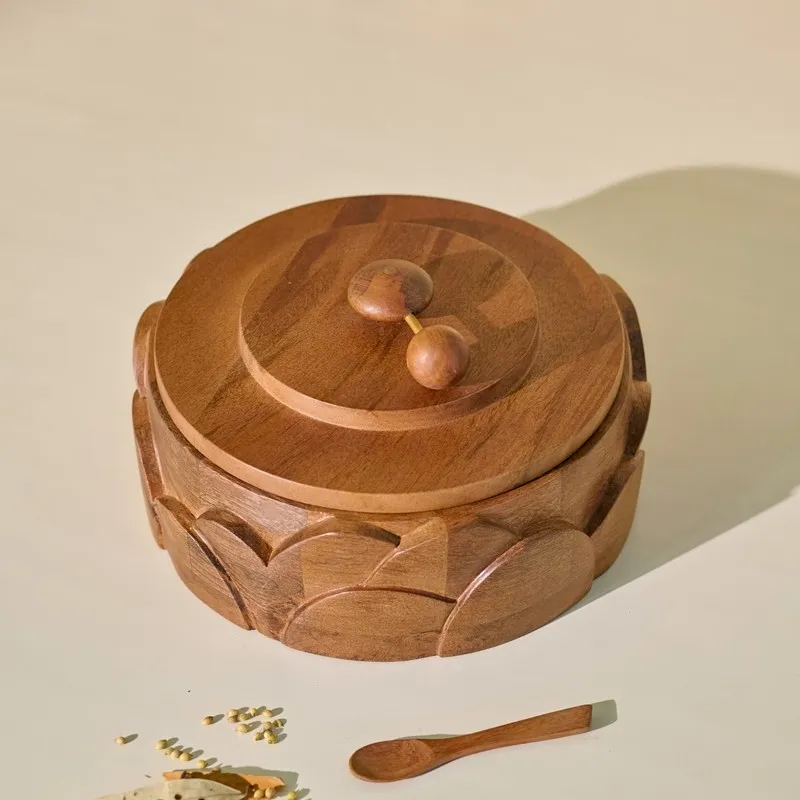 Closed round wooden masala box with carved arches, rotating handle and spices arranged in front.