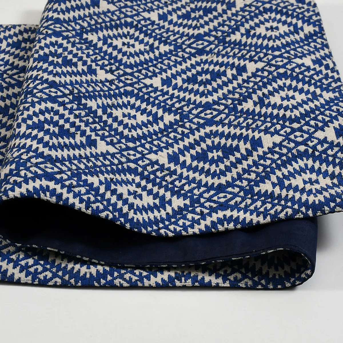Folded blue geometric table runner showing woven texture