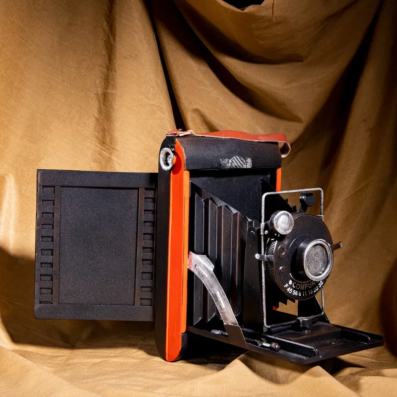 Black and red camera-inspired tabletop showpiece against a draped backdrop