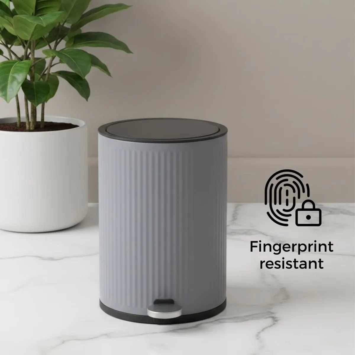 Grey ribbed dustbin with closed lid on a tabletop