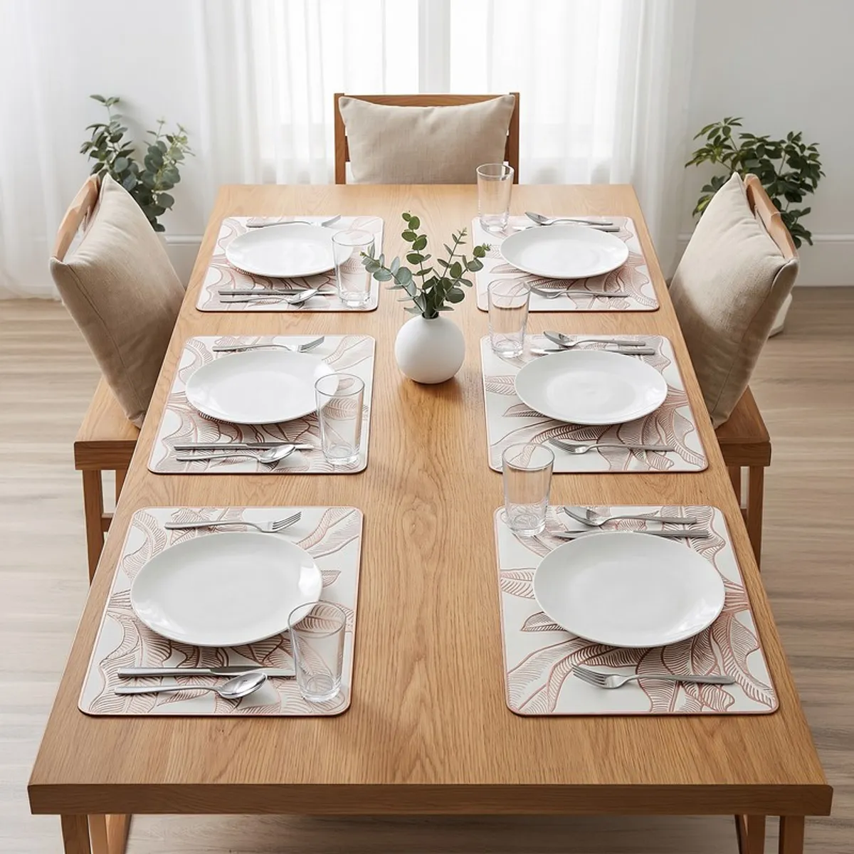 Set of six gold-toned rectangular placemats arranged on a wooden dining table
