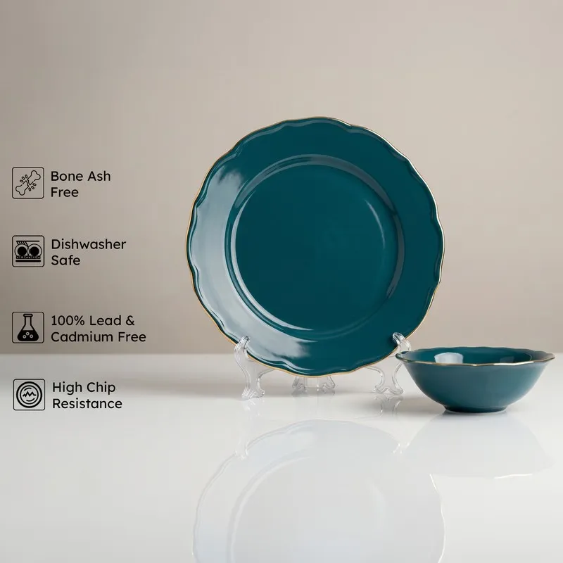 Single dark teal plate and bowl with gold rim on a neutral background