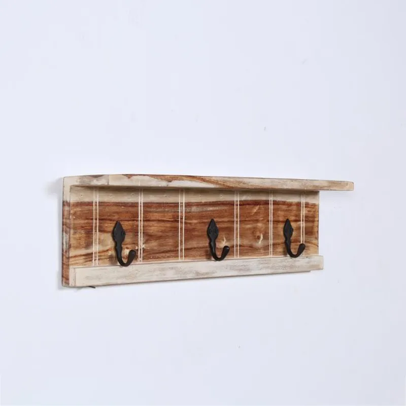 Angled view of a wooden wall-mounted hook rack with three black hooks