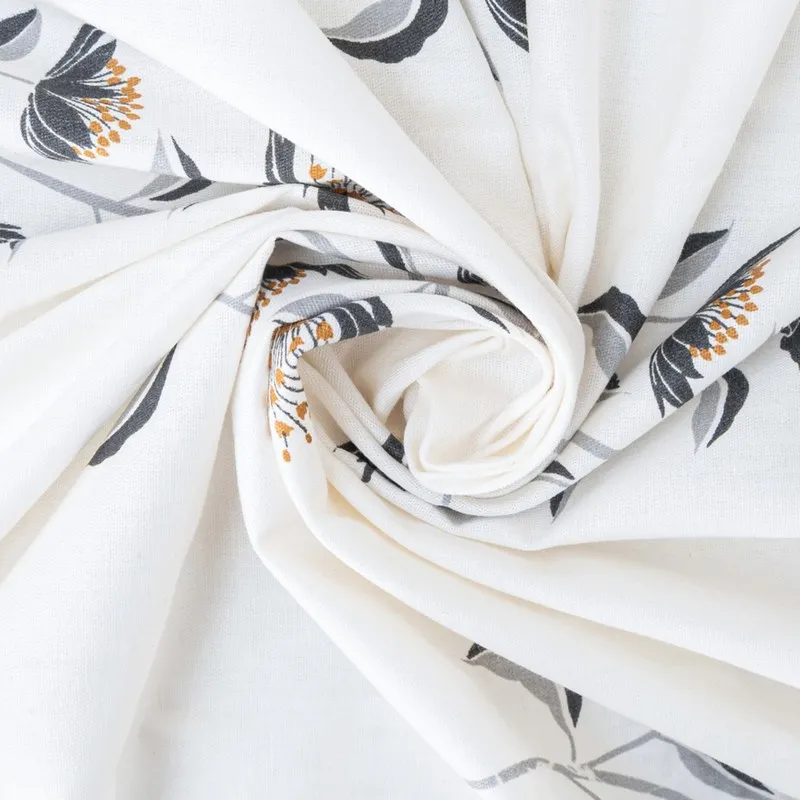 Close-up of white cotton fabric with floral print gathered in soft folds