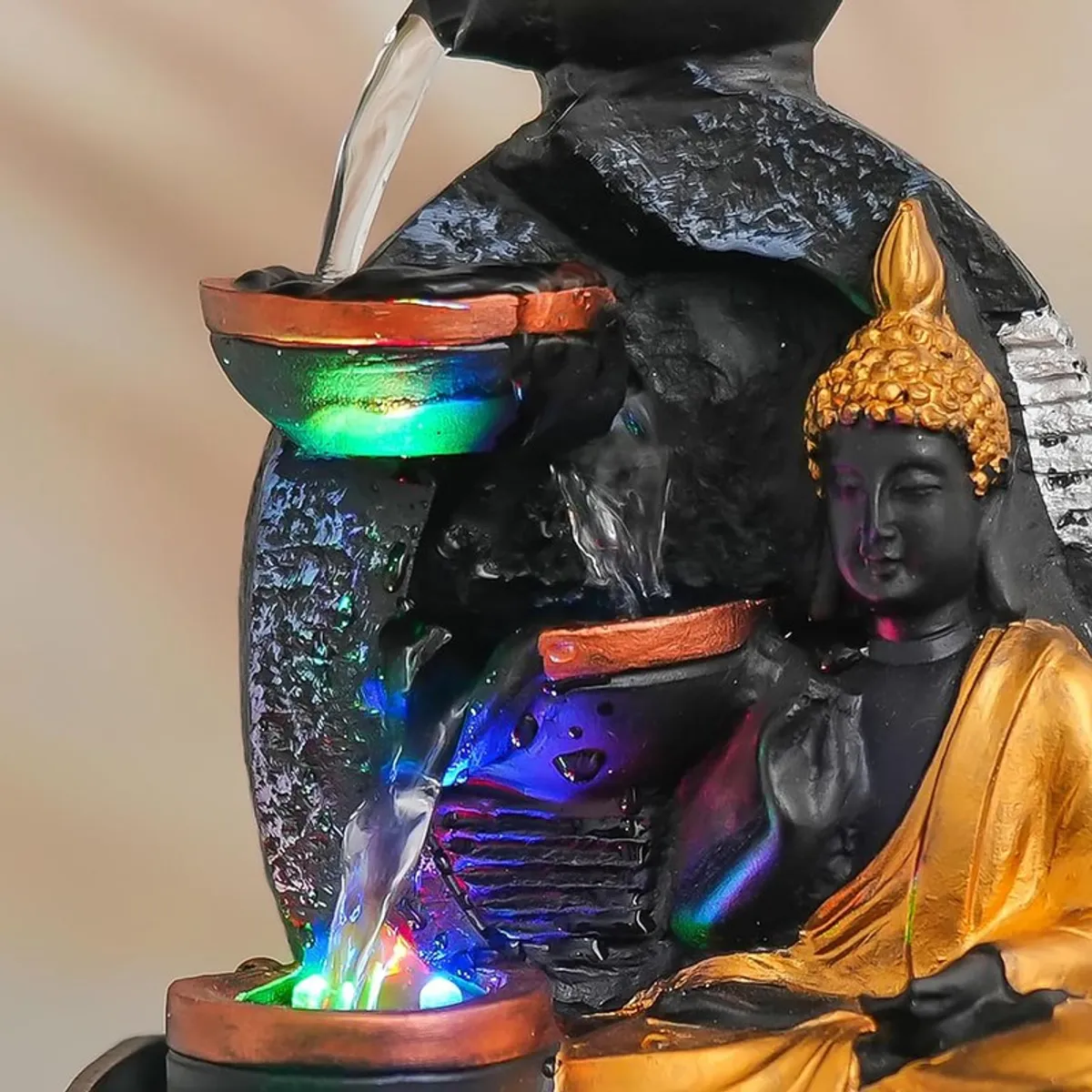 Close-up of upper bowls, water flow and Buddha figure with coloured LED glow