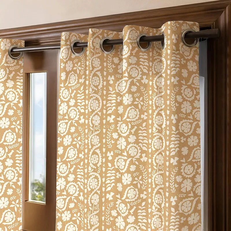 Close-up of beige floral printed curtain with eyelets on a dark curtain rod