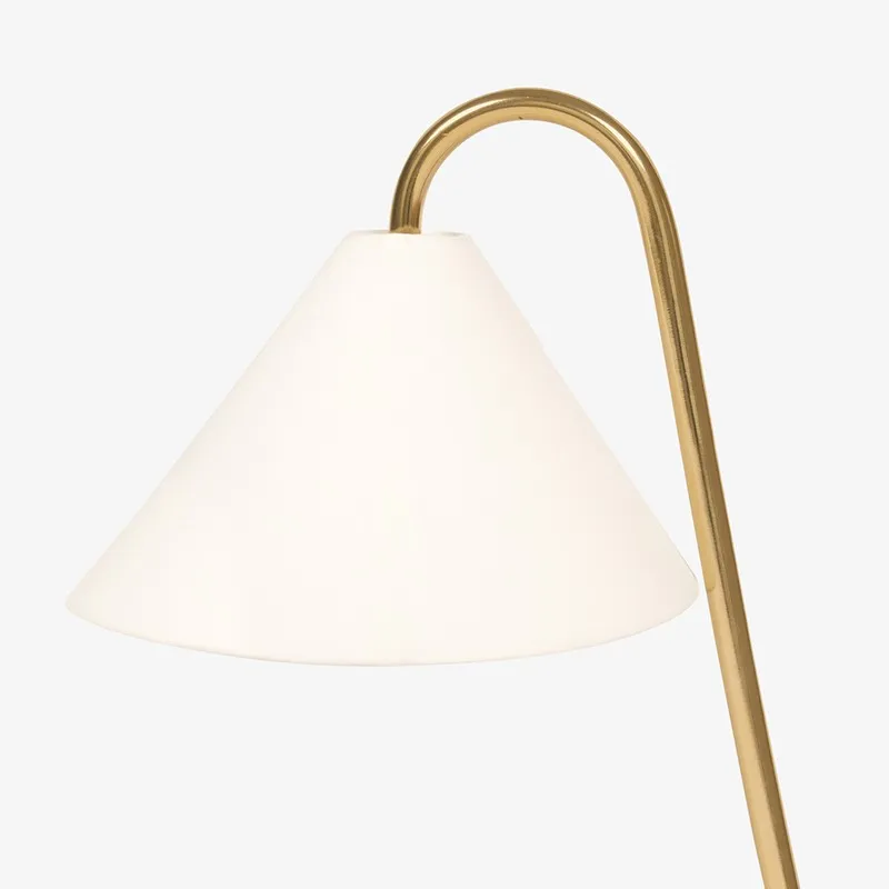 Close-up of white shade and curved gold neck on table lamp