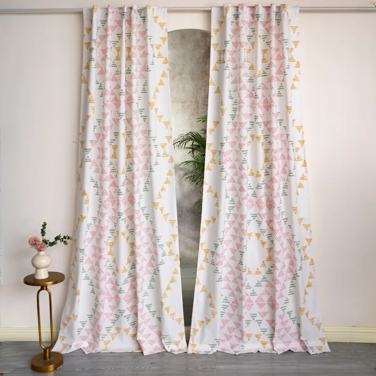Pair of white geometric print curtains hanging in a bright room