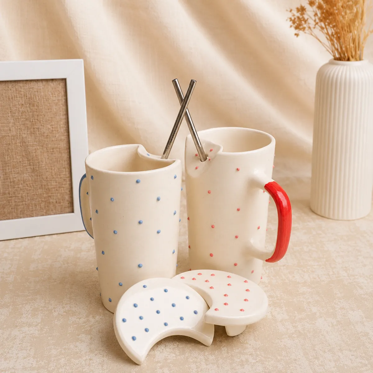 Two dotted ceramic sippers and matching round lids arranged together