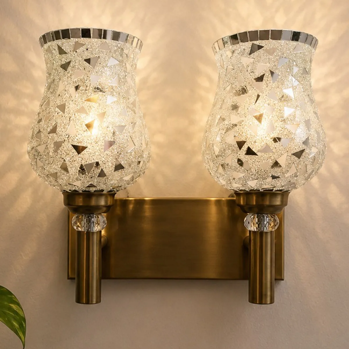 Close view of the illuminated multicolour mosaic glass shades and gold-toned wall plate.