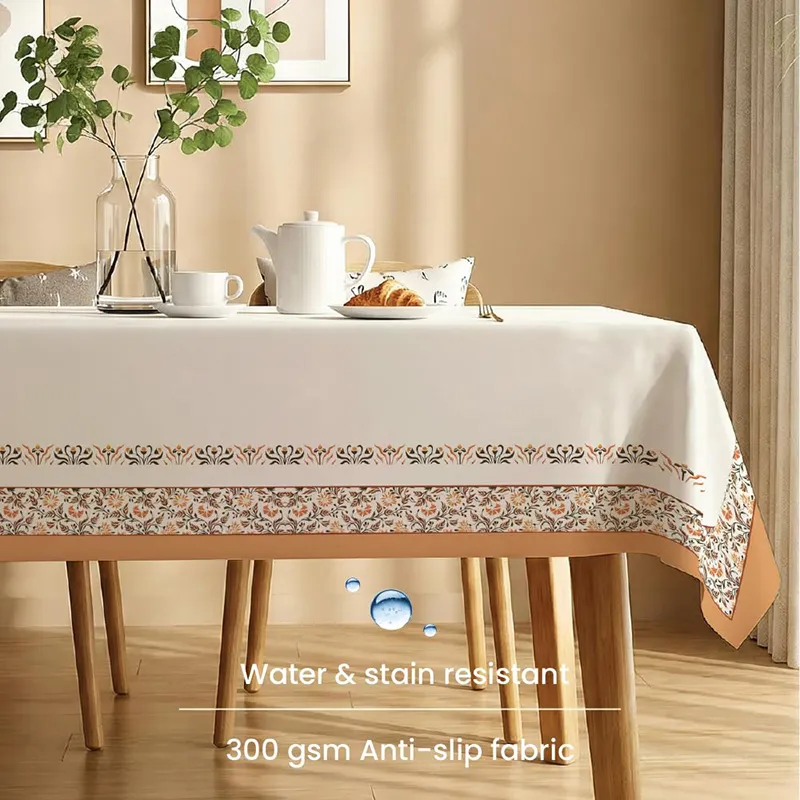White table cover with printed border draped over a wooden dining table