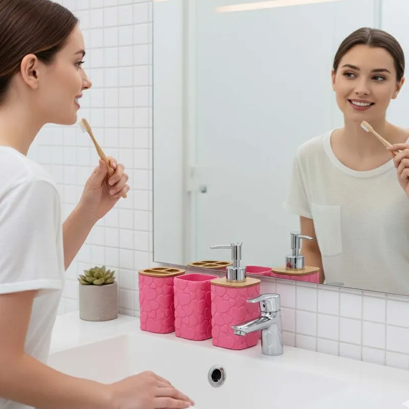 Pink bathroom accessories arranged beside a basin and mirror