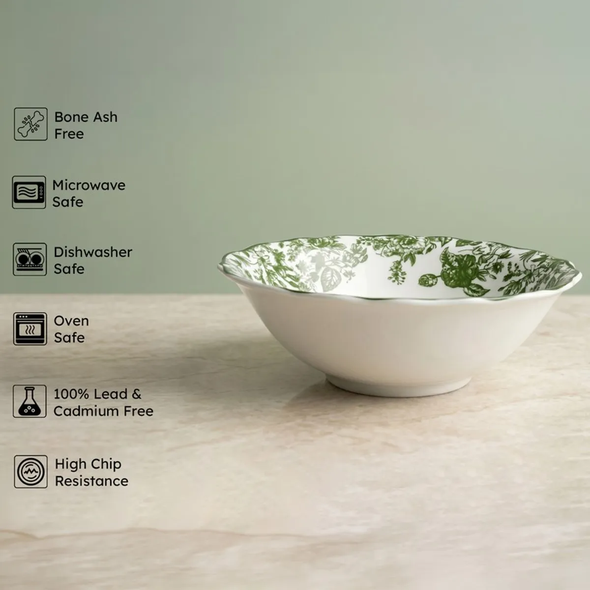 White porcelain serving bowl with green floral interior on a light surface