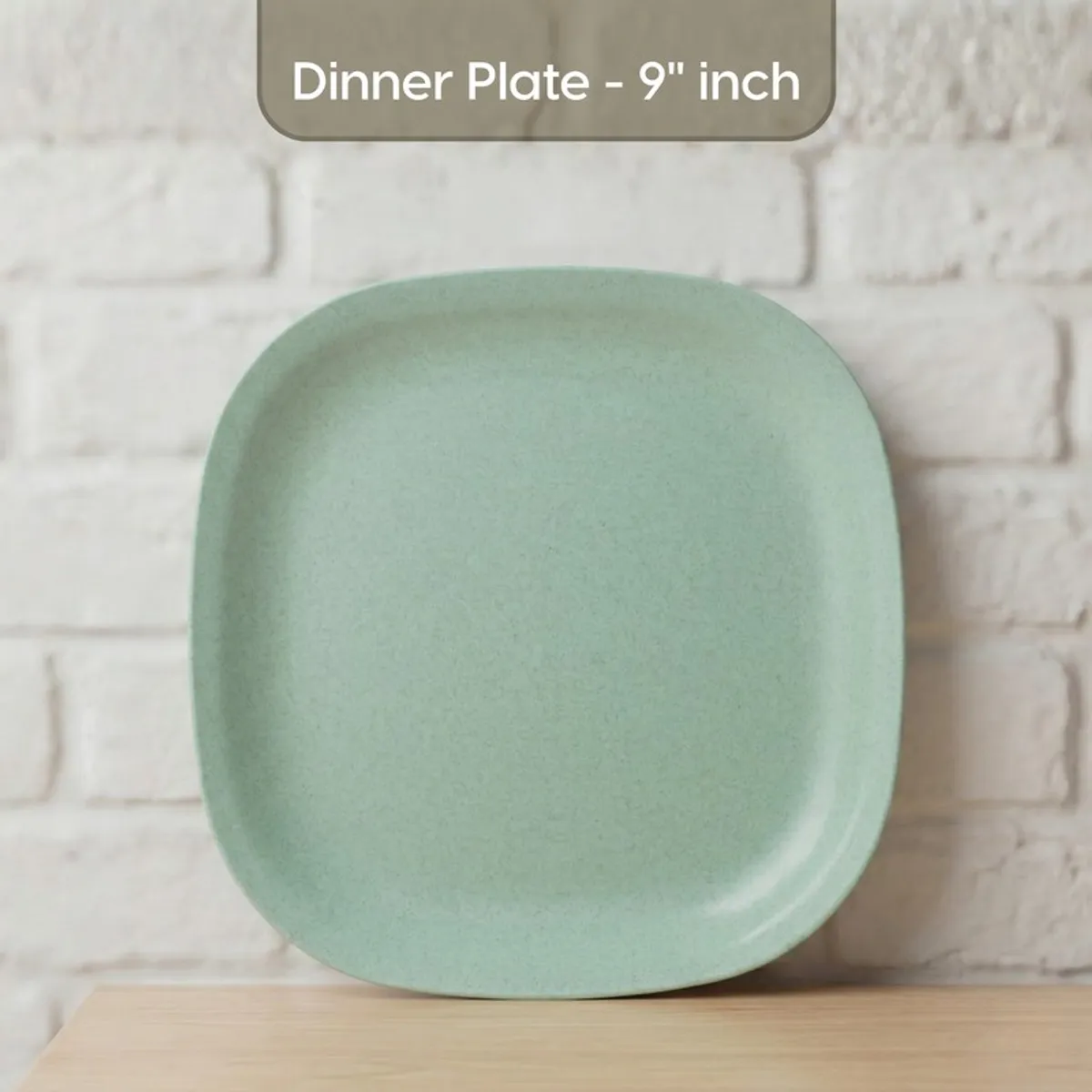 Green square plate shown upright against a white brick background
