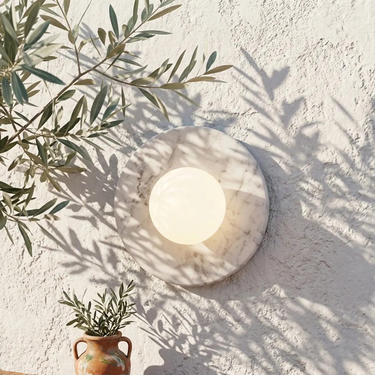 Round marble-look wall lamp with white globe on a textured white wall