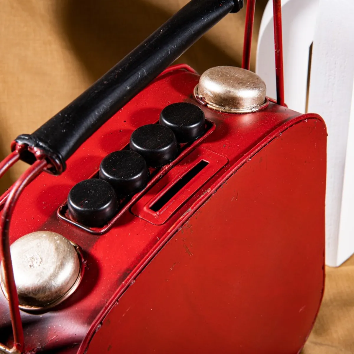 Top detail of red radio-style showpiece showing coin slot and black buttons