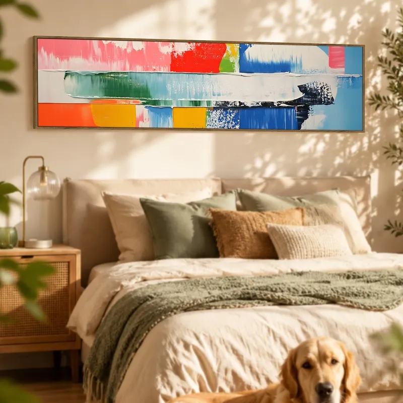 Panoramic multicolour abstract canvas hung above a bed in a sunlit bedroom.