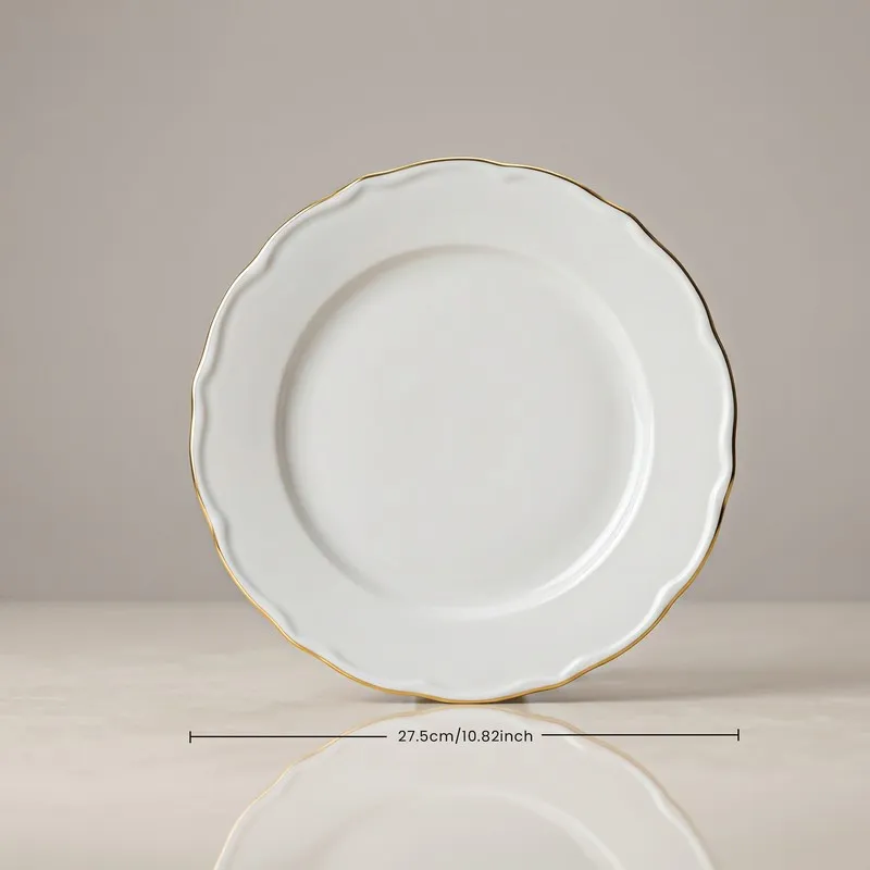 Single white porcelain dinner plate with a gold rim